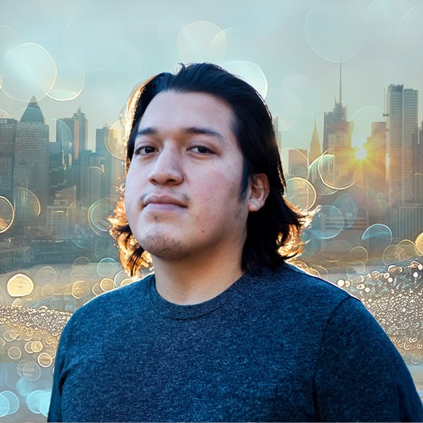 NYCOSH - A man with shoulder-length dark hair and a gray shirt stands outdoors with a city skyline and sun in the background.