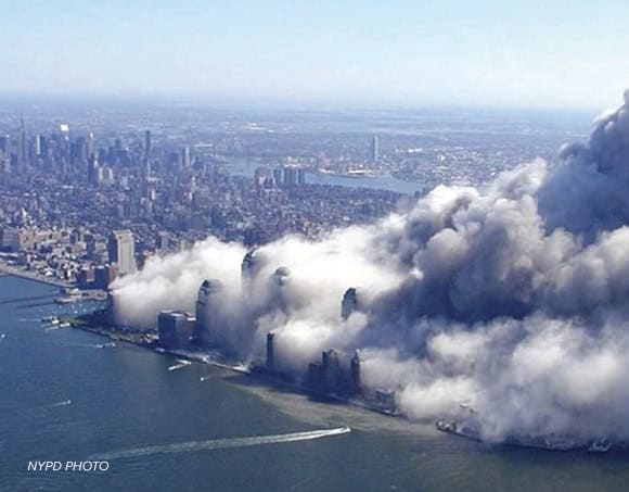 NYCOSH - Aerial view of lower Manhattan with thick smoke rising from buildings near the waterfront after the September 11, 2001 attacks, an event that later led to the creation of the WTC Health Program for responders and survivors.